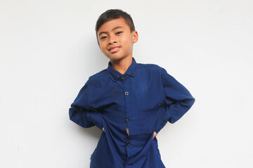 Smiling boy wearing blue shirt while looking at the camera isolated on white background
