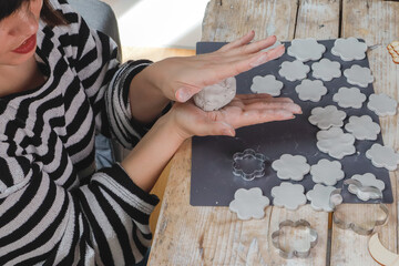 A girl, a woman sculpts from clay and paints