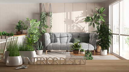 Wooden table, desk or shelf with potted grass plant, house keys and 3D letters making the words interior design, over modern living room and kitchen, urban jungle interior design