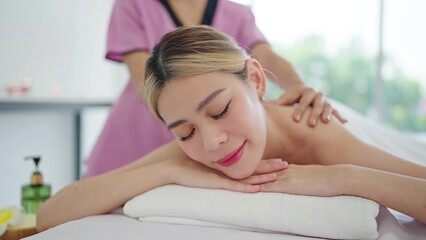 Obraz na płótnie Canvas Close up face of relaxed young Asian woman lying on spa bed closed eyes and relaxed. Spa treatment, body relaxation concept