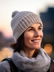 Portrait of a beautiful young woman wearing winter hat and scarf outdoors