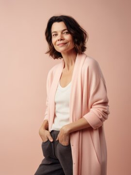 Portrait of a beautiful middle-aged woman in a pink jacket on a pink background