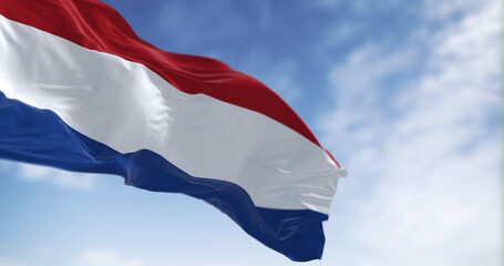 The national flag of the Netherlands waving in the wind on a sunny day