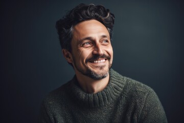 Fototapeta premium Portrait of a smiling man in a sweater on a dark background