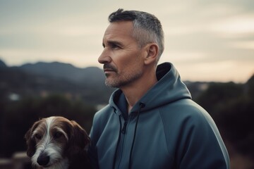 Handsome middle-aged man with his dog in the mountains.