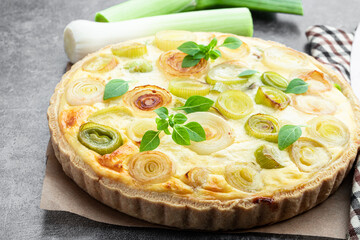 Quiche with leek and cheese on gray background