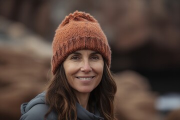 Portrait of a smiling woman in a knitted hat looking at the camera