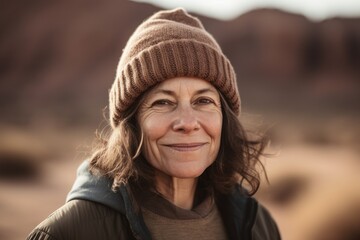 Portrait of smiling senior woman in hat and jacket in the desert