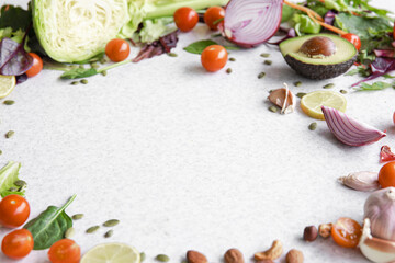 Vegetables, nuts and seeds on a white table in the form of a frame, copy space.