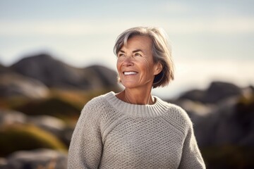 Fototapeta na wymiar Portrait of happy senior woman standing on the beach on a sunny day