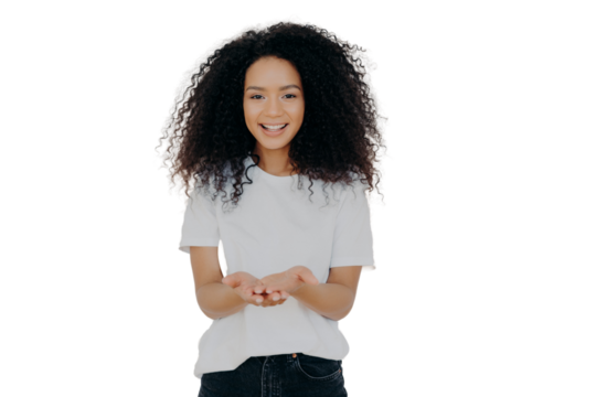 Glad dark skinned woman has cupped hands, asks to give something, smiles plesantly, has bushy frizzy hair, wears t shirt and jeans, isolated over white background. People and charity concept