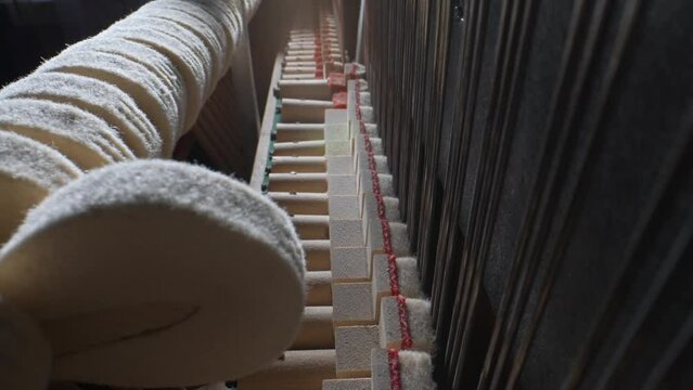 Inside the piano. Close-up view of hammers and strings inside the upright piano.