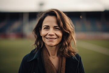 Portrait of a beautiful smiling woman in the stadium. Looking at camera.
