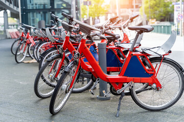 Closeup view many red city bikes parked in row at german Hamburg city street rental parking sharing station or sale. Healthy ecology urban transportation. Sport environmental transport infrastructure
