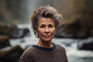 Portrait of a beautiful middle-aged woman on a background of a waterfall