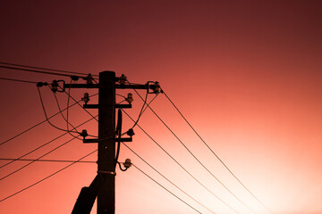 Silhouette of an electric pole against the sky.