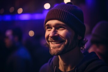 Portrait of a smiling young man in a hat at a party