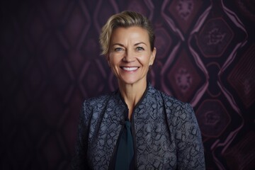 Portrait of beautiful mature woman smiling at camera against purple background.