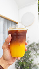 Drink scene - Dark Coffee with Orange Juice on The hand - Take A way with Blurred white Coffee Cafe Blackground 