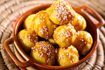 luqaimat or Lotus Gaimat sweet balls with sesame seeds served in dish isolated on table top view of arabic dessert