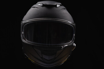 Black motorcycle helmet on dark background, space for text 