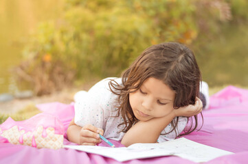 concentrated girl coloring outdoors