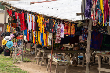 Various goods, including hats, bags and blankets for sale, in Queen Elizabeth National Park - obrazy, fototapety, plakaty