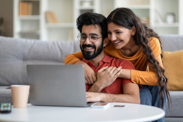 Portrait Of Romantic Indian Couple Using Laptop Together At Home