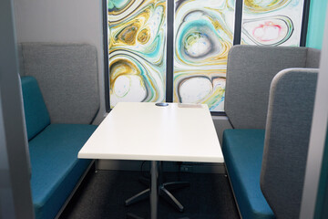 Empty shot of meeting room booth in coworking shared office space, hot desk