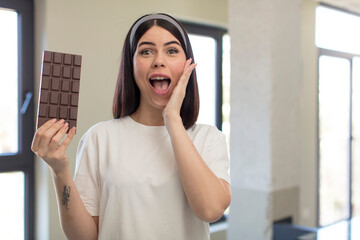 pretty young woman feeling happy and astonished at something unbelievable. chocolate concept