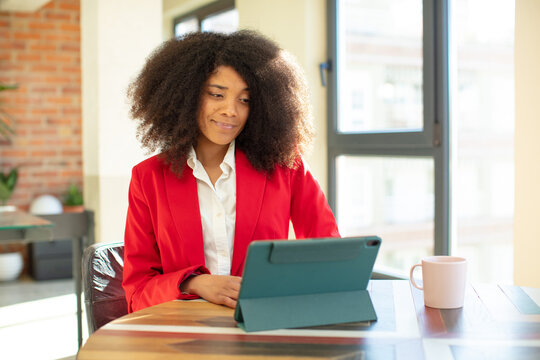 pretty afro black woman smiling and looking with a happy confident expression. businesswoman and laptop concept