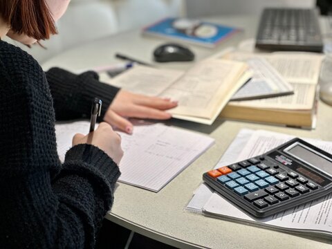 girl is preparing for the exam reading book works at the computer
