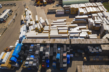 Top drone view over large stacks of wooden pallets for transporting goods at warehouse storage. High quality photo