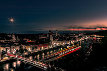 Fototapeta na wymiar Stadtlichter von Passau mit Sonnenuntergang und Mond