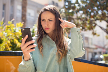 pretty woman looking surprised, realizing a new thought, idea or concept. smartphone concept