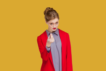 Portrait of serious young adult woman with red lips standing and showing money gesture, asking to...