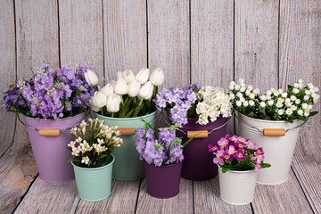 Maceteros con ramos de flores variadas.