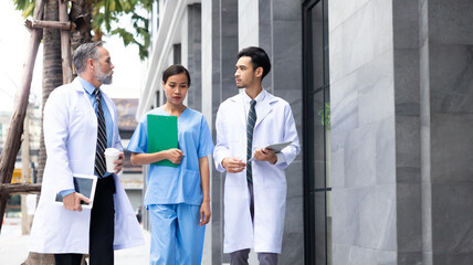 Professional medical staff people successful and teamwork concept. Diverse doctor and nurse walking and talking together outdoor at hospital medical wellness center