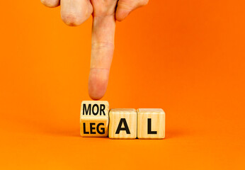 Legal or moral symbol. Businessman turns wooden cubes and changes the word Legal to Moral on a...