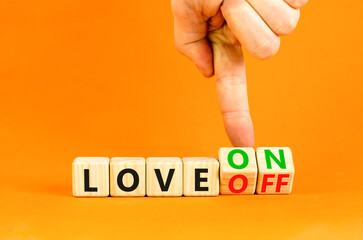 Love on or off symbol. Businessman turns wooden cubes and changes word Love off to Love on. Beautiful orange table orange background. Business and love on or off concept. Copy space.