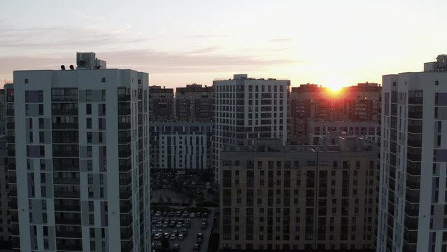 Top view of beautiful urban area at sunset. Stock footage. Residential high-rise buildings in modern area of city in sunset light of sun. Beautiful panorama of residential area with buildings on