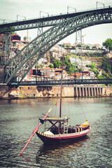 Porto city with traditional gondola boat and famous iron bridge- summer travel destination,  vacation, tourism in Portugal