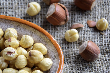 Ripe filbert kernels and hazelnuts in a shell on burlap background. Healthy nutrition, diet food. Copy space. Shallow depth of field. Selective focus.