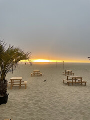 Praia ao entardecer: mesas no horizonte