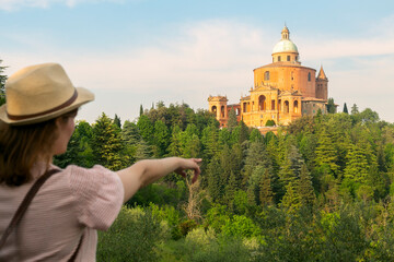 Bologna, San Luca - young girl with hat standing  looking the Sanctuary of the Madonna di San Luca, Bologna Italy © xamnex