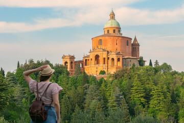 Bologna, San Luca - young girl with hat standing  looking the Sanctuary of the Madonna di San Luca, Bologna Italy © xamnex