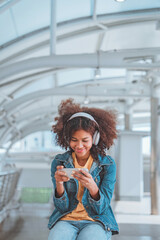 Young tourist African American woman wearing headphones and enjoying music on the urban city, Female listening to music on the town