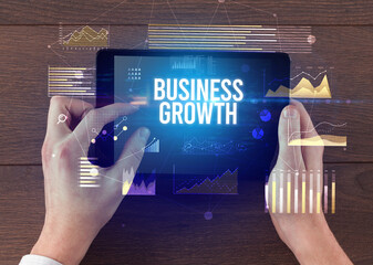 Close-up of hands holding tablet with business inscription