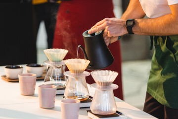 Pouring water over into a coffee pot.