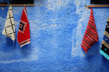 Traditional morocan carpets in Chefchaouen street, the blue city in Morocco old town.